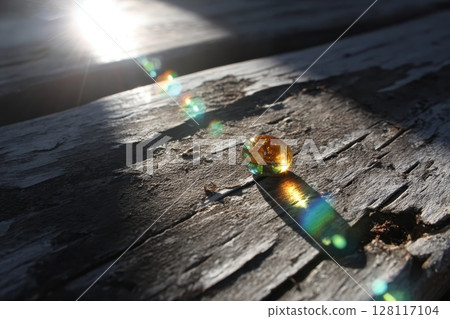 A small, yellow gemstone is sitting on a wooden surface A small, yellow gemstone is sitting on a wooden surface 128117104