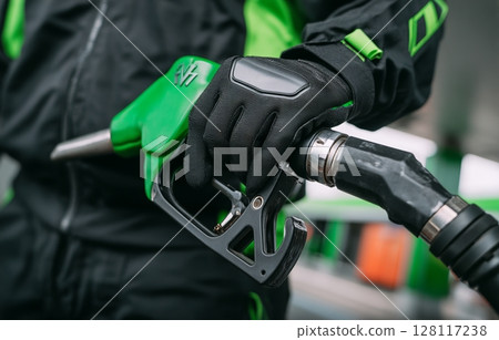 In a close-up shot, a hand is seen gripping the power cable of an environmentally friendly electric car that produces zero emissions 128117238