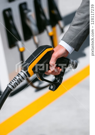 A close-up shot shows a hand gripping the power cable of an electric car with zero emissions, which is friendly to the environment 128117239