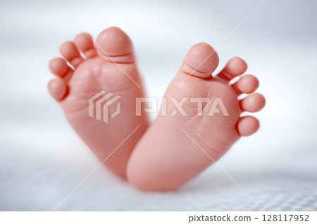Newborn baby's tiny feet come into focus as the diaper is changed 128117952