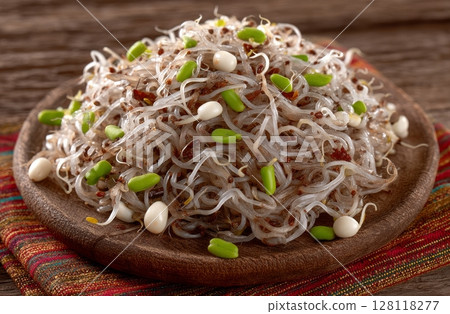 Fresh lentil and wheat sprouts mixed with carrot, raisins, and olive create a salad 128118277