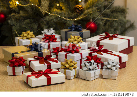 聖誕樹前排成一列的禮物盒 聖誕樹前排成一列的禮物盒 128119078