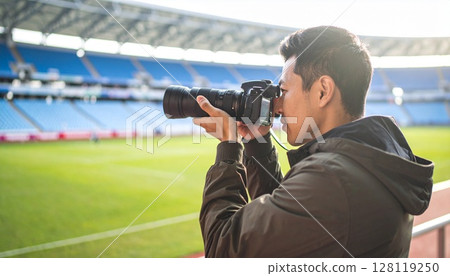 一名男子在球場內手持長焦相機 128119250