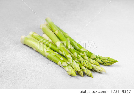 Pile of fresh raw green asparagus or sparrowgrass stems on light textured background Pile of fresh raw green asparagus or sparrowgrass stems on light textured background 128119347