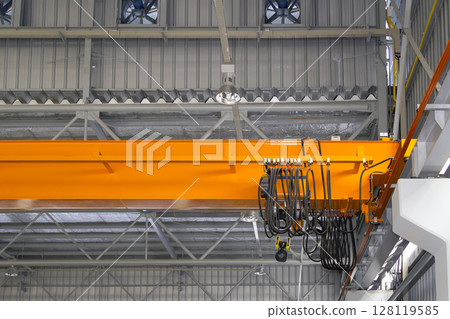 Overhead crane or lifting equipment inside factory or warehouse. 128119585