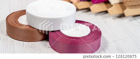 Colored ribbons and lace in coils for hobbies 128120875