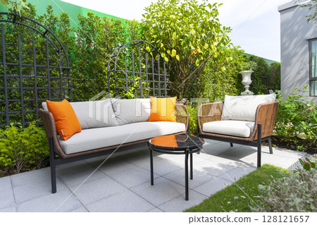 Patio. Garden. Outdoor living space with couch, table and pillow. 128121657