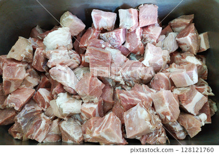 pieces of fresh pork meat are cut and placed in an iron container pieces of fresh pork meat are cut and placed in an iron container 128121760