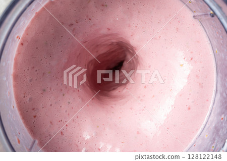 The process of making a strawberry milkshake, whisking all the ingredients in a blender. The process of making a strawberry milkshake, whisking all the ingredients in a blender. 128122148