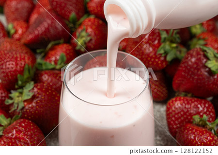 Strawberry sweet yogurt poured from bottle to glass. 128122152