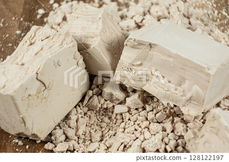Compressed fresh yeast cubes close-up on a wooden background. Compressed fresh yeast cubes close-up on a wooden background. 128122197