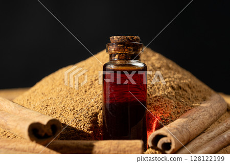 Natural cinnamon essential oil in a glass bottle close-up. Natural cinnamon essential oil in a glass bottle close-up. 128122199