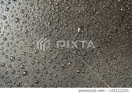 Water droplets on a cast iron macro surface. Cast iron cookware care, rust resistant, abstract pattern 128122201
