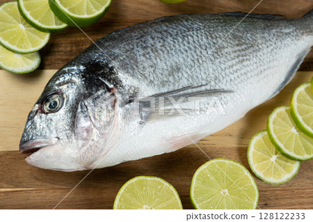 Fresh Raw Dorado Sea Bream Fish with Lime Slices Fresh Raw Dorado Sea Bream Fish with Lime Slices 128122233