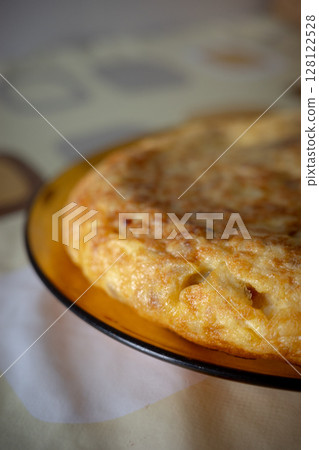 Traditional Spanish Potato Omelette on a Rustic Plate with Warm Light Traditional Spanish Potato Omelette on a Rustic Plate with Warm Light 128122528