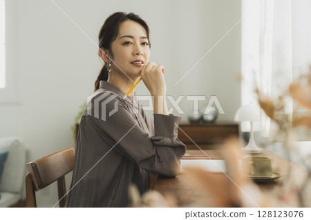 Woman at her desk at home 128123076
