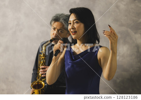 一名男子吹奏薩克斯，一名女子唱歌 128123186