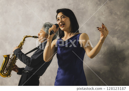 A man playing saxophone and a woman singing 128123187