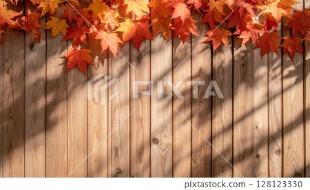 Seamless background of lightly layered red and orange autumn leaves on antique wood 128123330