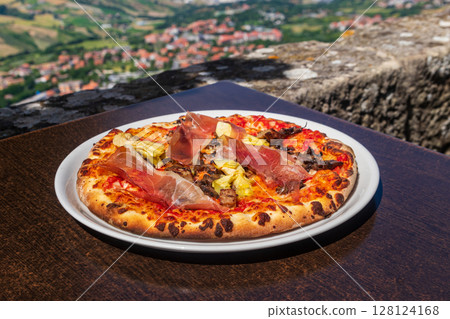 Delicious fresh pizza on a table Delicious fresh pizza on a table 128124168