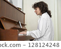 A Young Musician Ensemble Skillfully Playing the Grand Piano in a Cozy and Inviting Setting 128124248