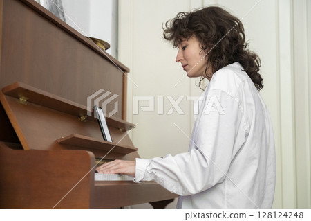 A Young Musician Ensemble Skillfully Playing the Grand Piano in a Cozy and Inviting Setting 128124248