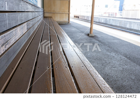 A wooden bench on a retro train station platform 128124472