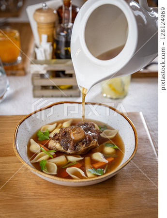 Oxtail soup being served in a restaurant Oxtail soup being served in a restaurant 128124969