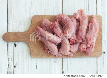 Raw fresh chicken necks on a cutting board. 128124979