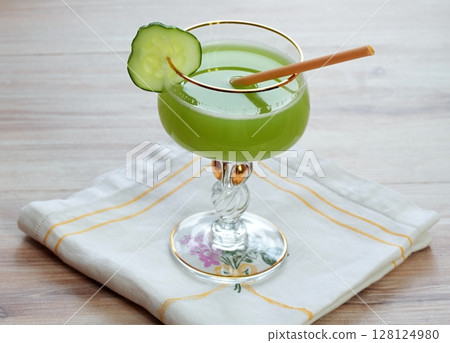 Delicious smoothie  from cucumbers in glass decorated with gold on wooden table. 128124980