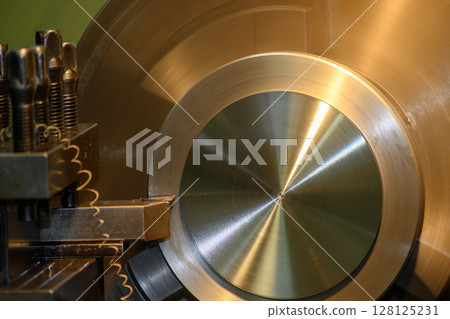 Close up scene the lathe machine rough cutting the brass material parts by chip insert tool. 128125231