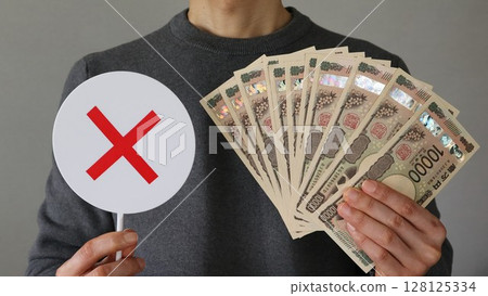 一個人拿著大量的10,000日元鈔票和一個十字標記 一個人拿著大量的10,000日元鈔票和一個十字標記 128125334