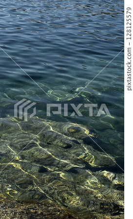 Clear Blue Water with Submerged Coastal Rocks Clear Blue Water with Submerged Coastal Rocks 128125579