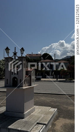 A clean white monument in a Greek plaza surrounded by palm trees under a clear sky, ideal for travel and culture visuals. A clean white monument in a Greek plaza surrounded by palm trees under a clear sky, ideal for travel and culture visuals. 128125625
