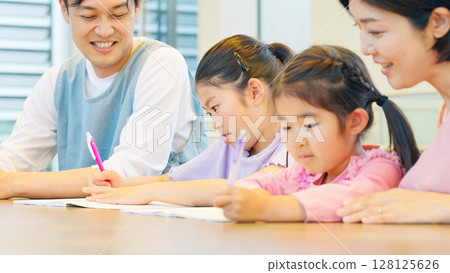 Children studying and care staff watching over them Children studying and care staff watching over them 128125626
