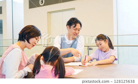 Children studying and care staff watching over them 128125638