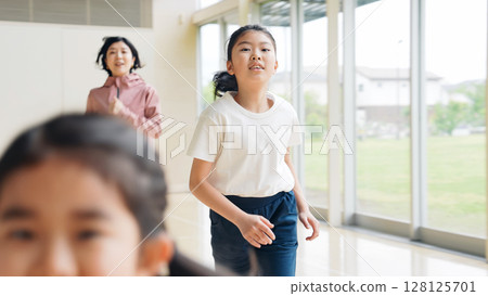 一個女孩和一位女老師在體育館跑步 128125701