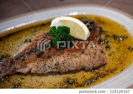 Sole meuniere, classic French dish of pan fried sole in butter with lemon and parsley 128126167