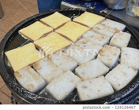 在早餐店裡拍攝平底鍋裡正在煎熟的法式吐司與蘿蔔糕 在早餐店裡拍攝平底鍋裡正在煎熟的法式吐司與蘿蔔糕 128126467