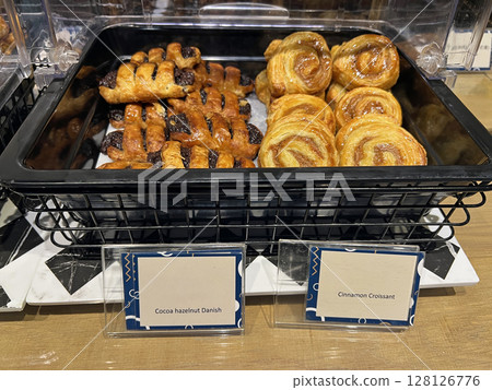 Photographing neatly arranged cinnamon rolls and chocolate danishes in a cafeteria Photographing neatly arranged cinnamon rolls and chocolate danishes in a cafeteria 128126776