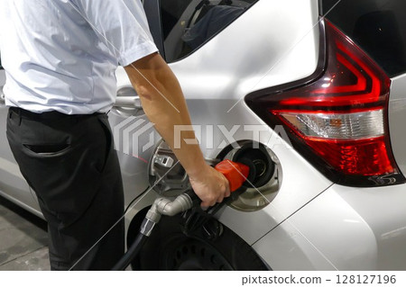 Male office worker refueling a car 2 128127196