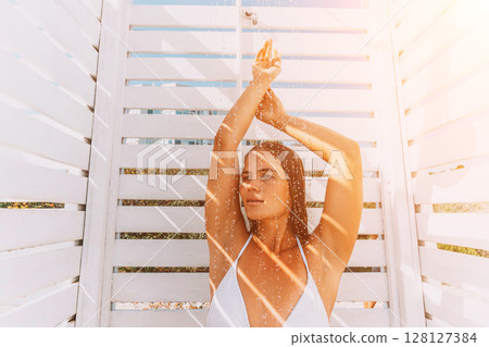 Woman Beach Summer: Sunlit Pose, White Cabana, Relaxation; Coastal Vacation Photography. Woman Beach Summer: Sunlit Pose, White Cabana, Relaxation; Coastal Vacation Photography. 128127384