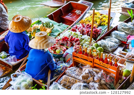 Traditional colorful floating market in Damnoen Saduak near Bangkok in Thailand. Fruit sellers at Damnoen Saduak floating market, Thailand. Traditional colorful floating market in Damnoen Saduak near Bangkok in Thailand. Fruit sellers at Damnoen Saduak floating market, Thailand. 128127992