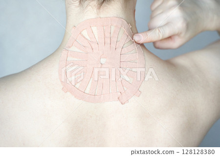 Female adult with therapeutic tape on neck for pain relief and muscle support Female adult with therapeutic tape on neck for pain relief and muscle support 128128380