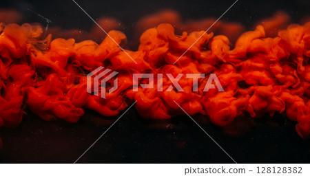 Ink cloud. Shimmer background. Defocused bright red color swirling vapor fume liquid floating on dark black acrylic creative abstraction. 128128382