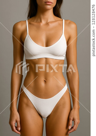 Fit Female Torso in White Underwear on a Simple Background. 128128476