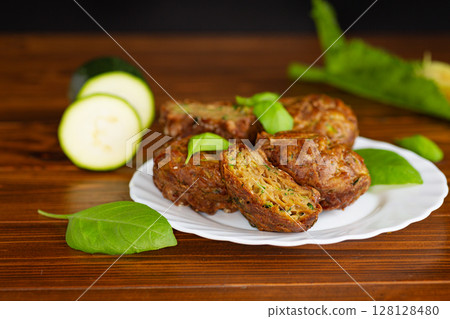 Healthy vegetable muffins with herbs and zucchini on a dark wooden table 128128480