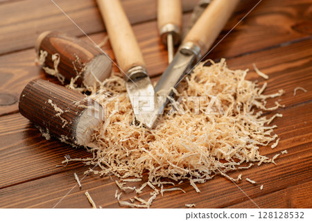 Carpentry tool set with wood shavings on wooden table 128128532
