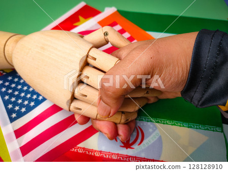 Hand shaking on a variety of flags in each country. 128128910