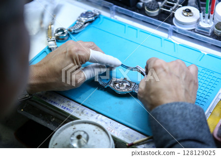 Repairing a wristwatch. Watch repair Repairing a wristwatch. Watch repair 128129025